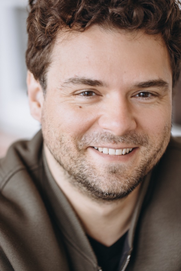 Ilya Truskovsky in an olive jacket, smiling